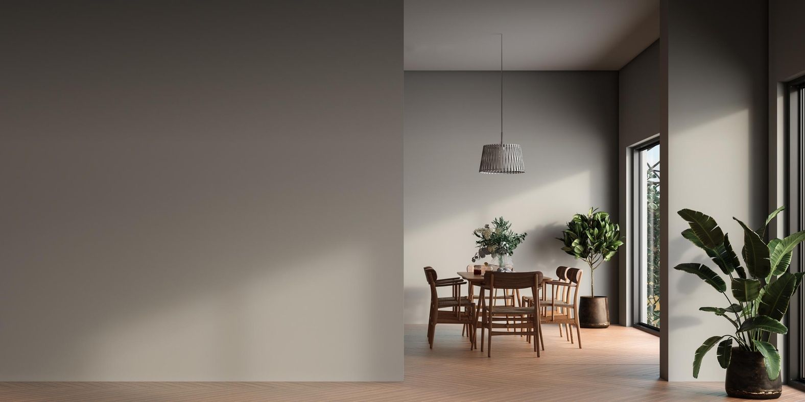 Esszimmer mit rundem Holztisch, vier Stühlen, zwei großen Pflanzen und einer Hängeleuchte vor hellem Hintergrund.